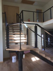 a modern staircase with black cable railings